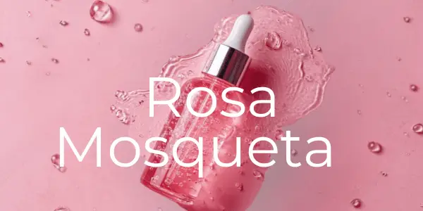 Frasco de sérum rosa no centro com gotas de sérum derramadas, fundo rosa claro e o texto 'Rosa Mosqueta' ao centro. "Reduzir rugas e prevenir linhas"