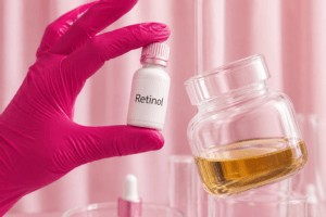 "Mão com luva segurando um frasco de retinol, representando a ciência por trás do ativo e sua eficácia na redução de rugas."